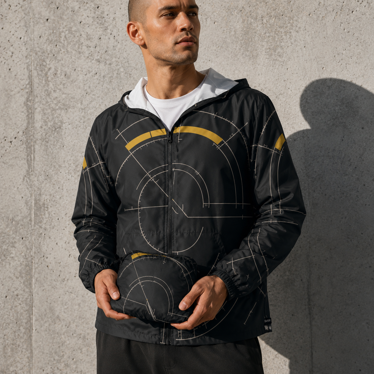 BKS Hours Arc Windbreaker social — model holding jacket, concrete wall shadow